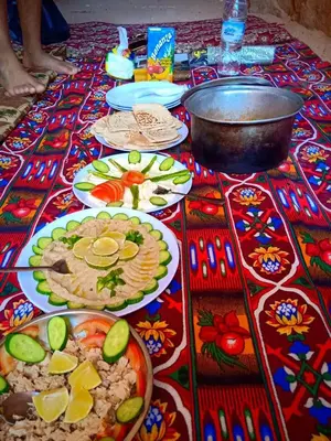 a table with plates of food on a colorful table cloth at Desert Tree camp&tours in Wadi Rum