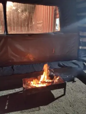 a stove with a pot on fire in a truck at Mujib Castle Gate Camp in Dhībān