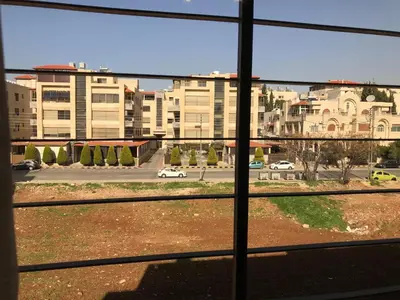 a view of a city street from a window at Behind Mecca Mall in Amman
