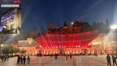 a group of people walking around a building with red lights at Al Midan Hotel in Amman