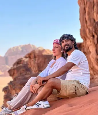 a man and a woman sitting in the desert at RUM SOlARIS BEDOUIN CAMP in Wadi Rum