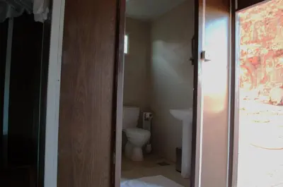 a bathroom with a toilet and a door open at Magic Wadi Rum in Wadi Rum
