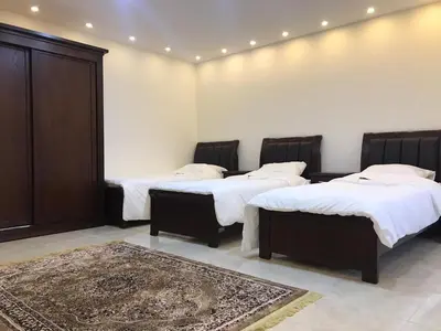 a room with three beds and a rug at Sultan Home in Wadi Musa