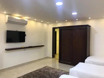 a room with a flat screen tv and a door at Sultan Home in Wadi Musa