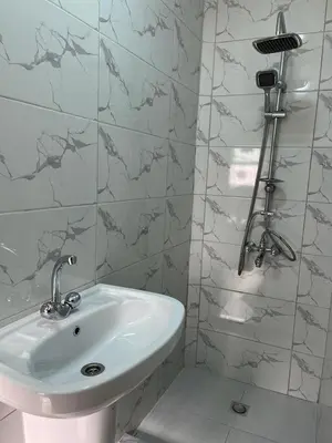 a white sink in a bathroom with marble tiles at Sultan Home in Wadi Musa