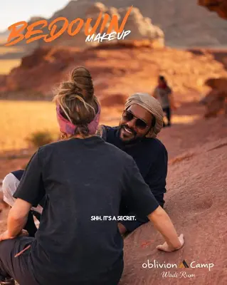 a man and a woman sitting on a dirt road at Oblivion Camp Wadi Rum in Wadi Rum