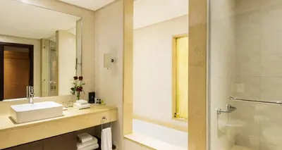 a bathroom with a sink and a shower at Corp Amman Hotel in Amman