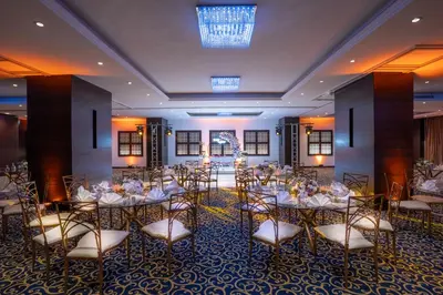 a banquet hall with tables and chairs in a room at Corp Amman Hotel in Amman