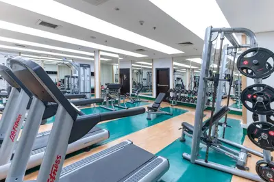 a gym with treadmills and elliptical machines at Corp Amman Hotel in Amman