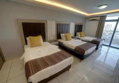 a hotel room with two beds and a large window at Shweiki International Hotel in Aqaba