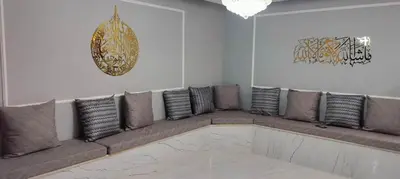 a living room with a long couch with pillows at Golden Rose Hotel in Aqaba