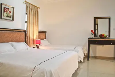 a hotel room with two beds and a mirror at Golden Rose Hotel in Aqaba
