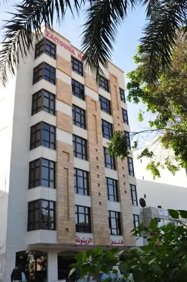 a tall building with a sign on it at Al Zaitouna Hotel in Aqaba