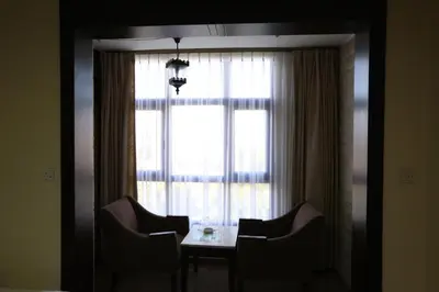 a dining room table with chairs in front of a window at Al Zaitouna Hotel in Aqaba