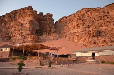 a building in front of a rocky mountain at Desert Magic Camp & Resort in Wadi Rum
