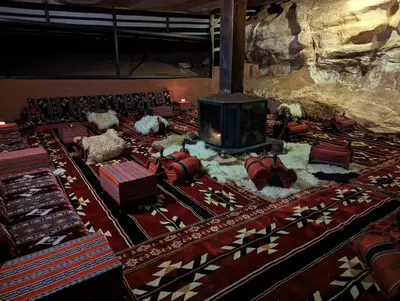 a room with a fireplace in a room with a rug at Desert Magic Camp & Resort in Wadi Rum