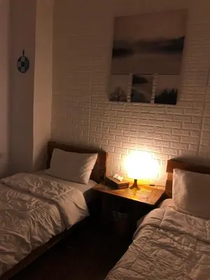 a room with two beds and a lamp on a table at The Cabin in Amman