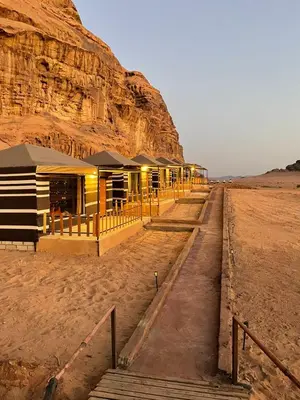 a row of resorts in the desert next to a mountain at North moon Camp in Wadi Rum