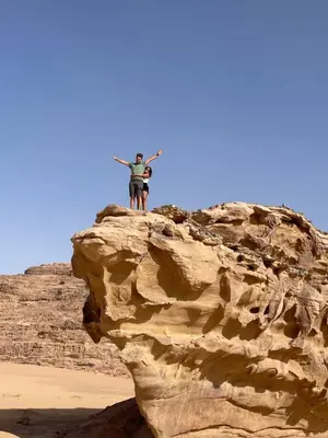 a man standing on top of a rock at North moon Camp in Wadi Rum