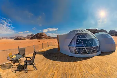two dome tents in the desert with a table and chairs at Wadi Rum UFO Luxotel in Wadi Rum