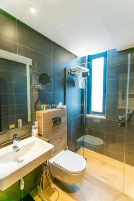 a bathroom with a toilet and a sink and a shower at The Compass Hotel in Amman
