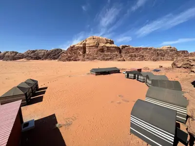 a desert with a group of chairs in the desert at Wadi Rum Old Bedouin Camp in Wadi Rum