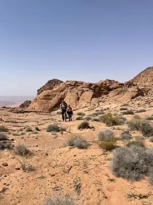 two people walking through the desert at Wadi Rum Old Bedouin Camp in Wadi Rum