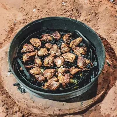 a bunch of meat cooking on a grill at Wadi Rum Bright Moon in Wadi Rum