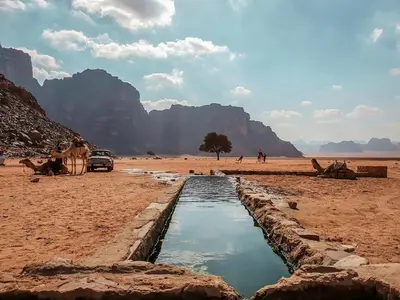 a water channel in the desert with mountains in the background at Wadi Rum Bright Moon in Wadi Rum