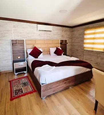 a bedroom with a large bed with red pillows at Seven Wonders Luxury Camp in Wadi Musa