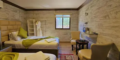 a bedroom with a bed and a table and chairs at Seven Wonders Luxury Camp in Wadi Musa