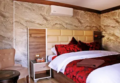 a bedroom with a large bed and a chair at Seven Wonders Luxury Camp in Wadi Musa