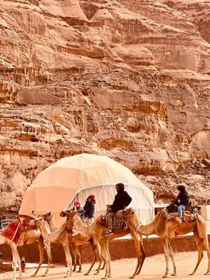 a group of people riding on horses in the desert at domes wadi Rum in Wadi Rum