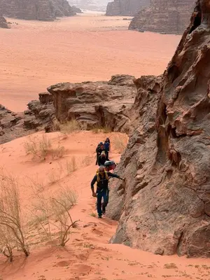 a group of people walking through the desert at Wadi rum Silk Road camp in Wadi Rum