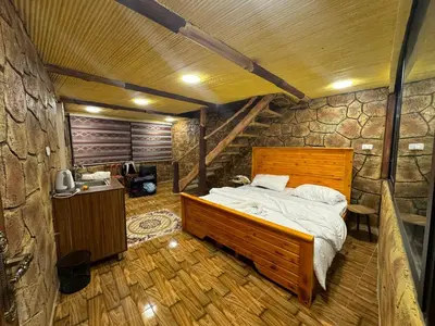 a bedroom with a bed and a stone wall at Dana Gate Lodge in Dana