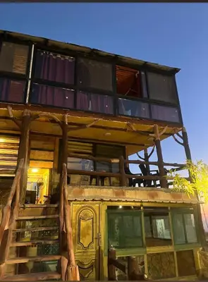 a tree house with a balcony on top of it at Dana Gate Lodge in Dana