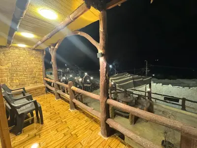 a room with a table and chairs on a wooden deck at Dana Gate Lodge in Dana