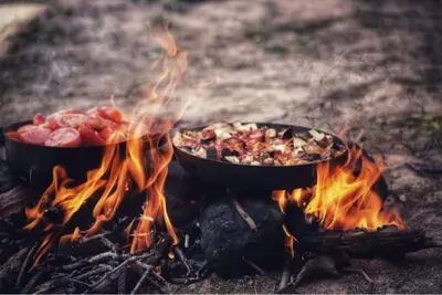 two pans of food sitting on a fire at Dana Gate Lodge in Dana