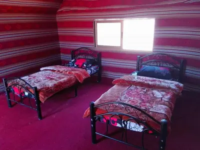 a room with two beds and two windows at Wadi rum Local guide camp in Wadi Rum
