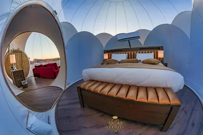a bedroom with a bed in a dome with a mirror at Wadi Rum Bubble Luxotel in Wadi Rum
