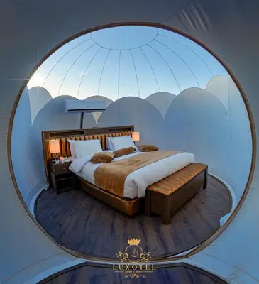 a bedroom with a large bed in a round mirror at Wadi Rum Bubble Luxotel in Wadi Rum