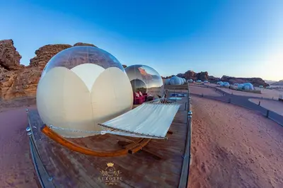 a row of domed observatories in the desert at Wadi Rum Bubble Luxotel in Wadi Rum