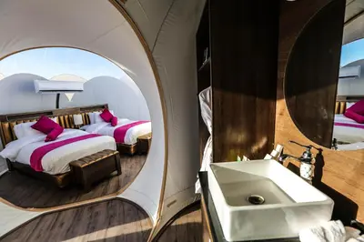 a bathroom with two beds and a sink and a mirror at Wadi Rum Bubble Luxotel in Wadi Rum