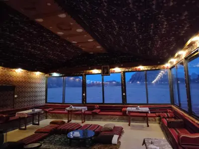 a large room with couches and tables and windows at Omar Ghazi Camp in Wadi Rum