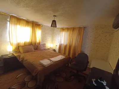 a bedroom with a bed and a chair and a window at Mhna guest house بيت الضيافة الريفي in Ajloun