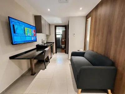 a living room with a couch and a television on a wall at Celino Hotel in Amman