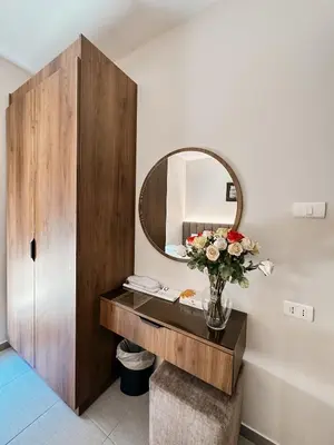 a bathroom with a mirror and a vase of flowers at Celino Hotel in Amman