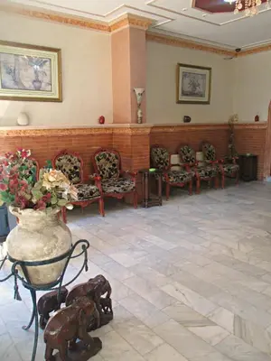 a court room with chairs and a vase of flowers at Sufara Hotel Suites in Amman
