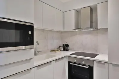 a white kitchen with a sink and a microwave at The St. Regis Amman in Amman