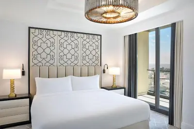a bedroom with a white bed and a large window at The St. Regis Amman in Amman